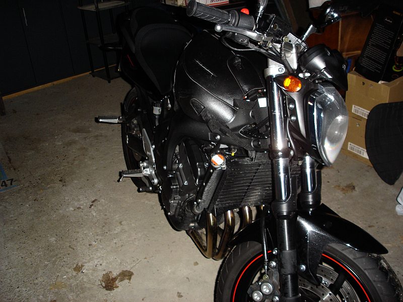 La FZ6-N noire de trois quarts avant, dans un garage ; les jantes sont cerclées d’un filet rouge.